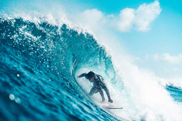 Photo d'un surfeur. I Le surf est une des activités en plein air listées.
